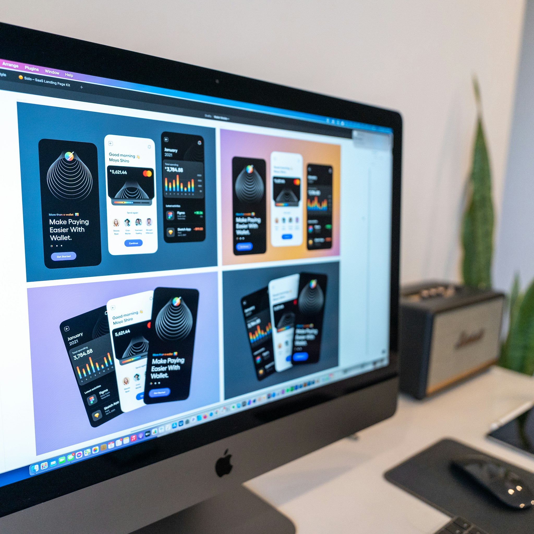 A vibrant and creative workspace featuring a designer intensely focusing on a colorful digital art project at a desk with various design tools scattered around.